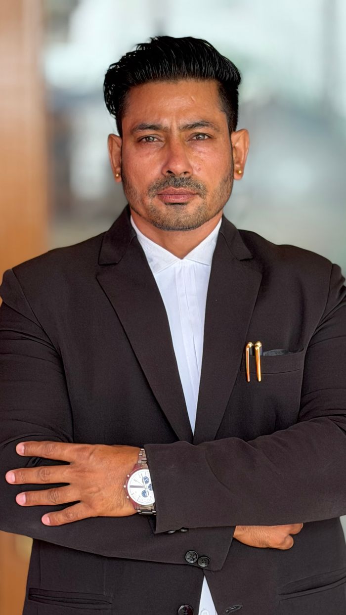 Portrait of a confident businessman in a formal suit with arms crossed, exuding professionalism.